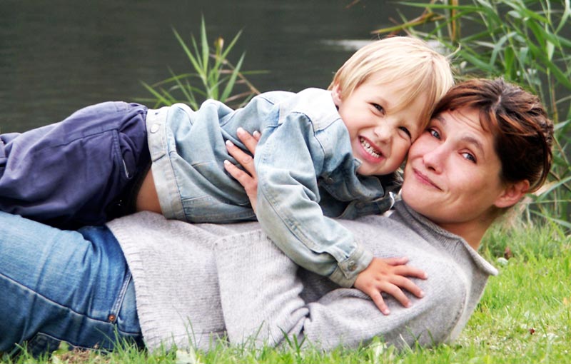 Mother and young son enjoying the simple life beside a peaceful river